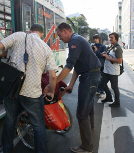 Christian Hausmann (ganz links) und Burkhard Lischka (3.v.l.) helfen Andreas Poppe beim Einsteigen in die Straßenbahn Linie 6 in Richtung Diesdorf.